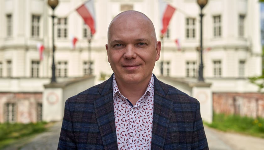 Paweł Kamiński, dyrektor OPT Zamek, na tle pałacu w Leśnicy