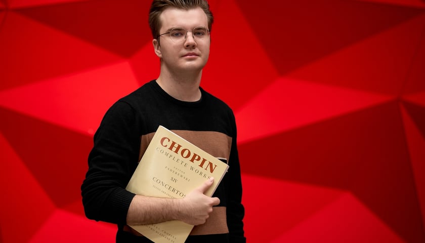Na zdjęciu pianista Piotr Alexewicz z wydaniem nutowym koncertów Chopina w sali czerwonej Narodowego Forum Muzyki