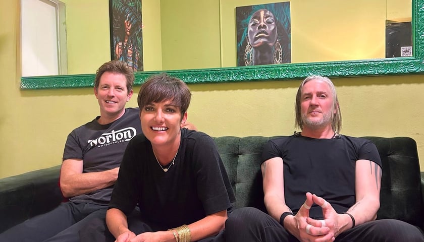 Muzycy Kosheen (w środku wokalistka Sian Evans) siedzący na kanapie