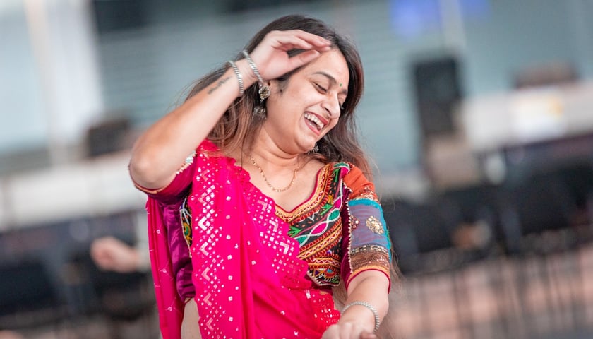 Kobieta w kolorowym ubraniu tańcząca w hali terminala na lotnisku we Wrocławiu, 2 listopada 2025