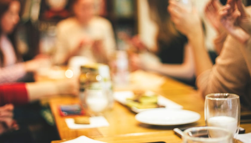 Na zdjęciu ludzie dyskutujący przy stole, zdjęcie ilustracyjne