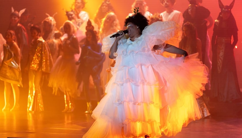 Scena ze spektaklu „Nie-Boska-Gala” podczas PPA. Na zdjęciu kobieta w białej sukni śpiewa do mikrofonu