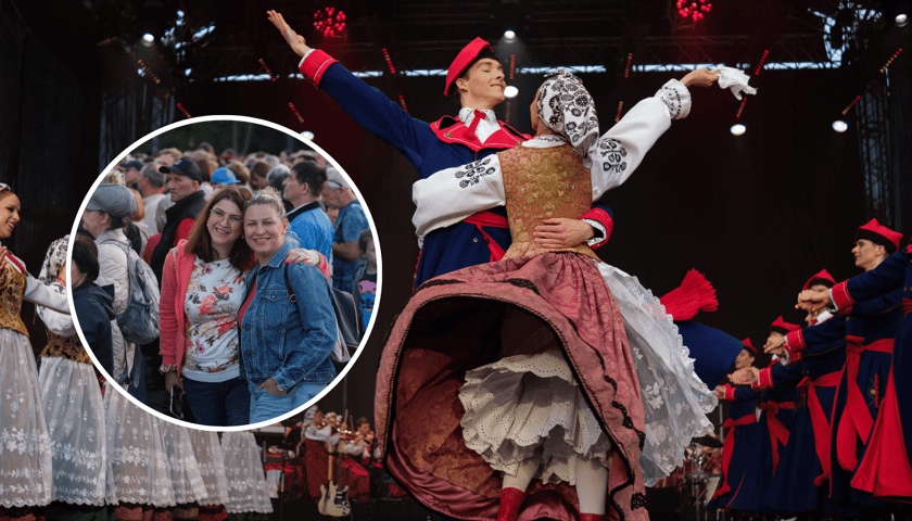 Dwójka tancerzy Mazowsza w ludowych strojach, w kółku są dwie kobiety biorące udział w koncercie na Placu Wolności