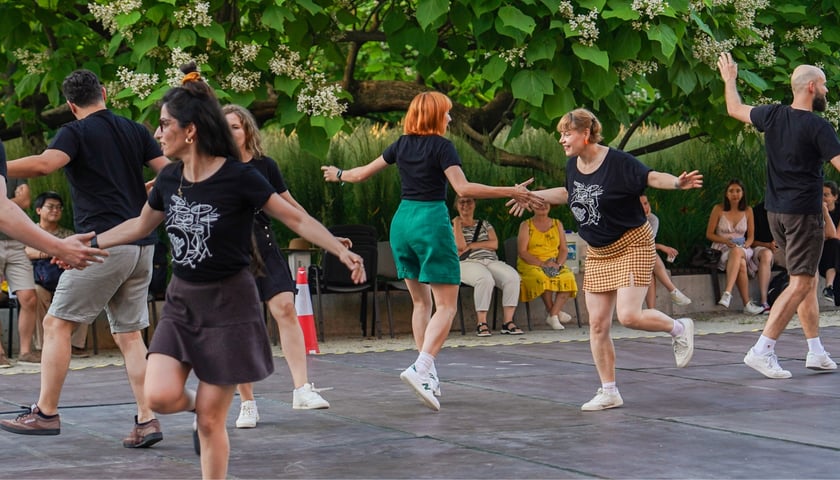 Grupa osób tańczy na parkiecie