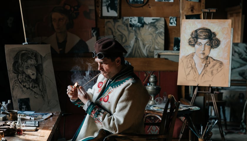 Na zdjęciu: Marcin Dorociński jako Witkacy, siedzący przy biurku w pracowni i odpalający fajkę