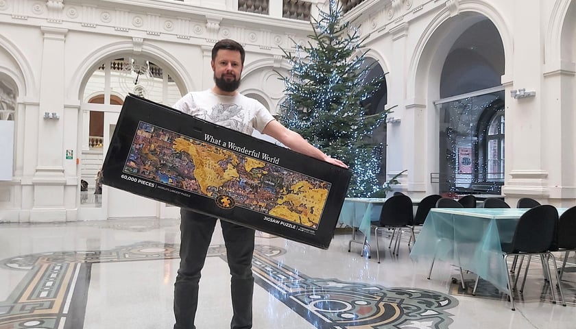 Na zdjęciu Michał Gołębiewicz, koordynator akcji z pudłem największych puzzli świata w Muzeum Narodowym we Wrocławiu