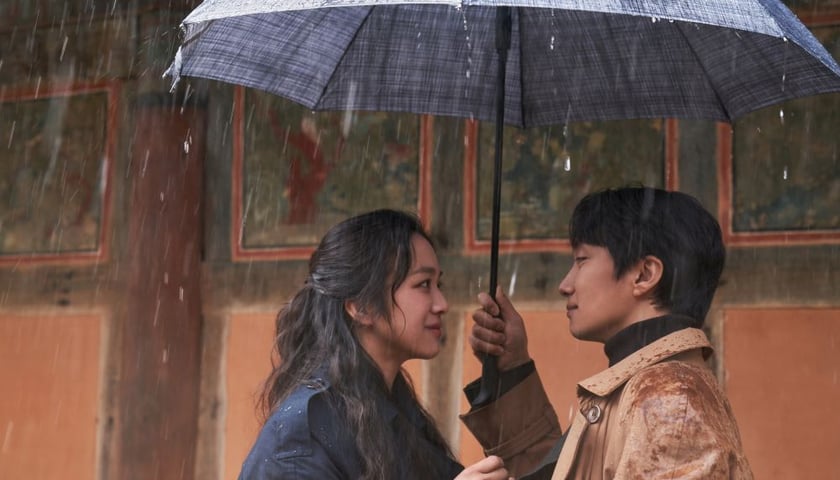 Na zdjęciu kobieta i mężczyzna pod parasolem, bohaterowie filmu „Podejrzana”