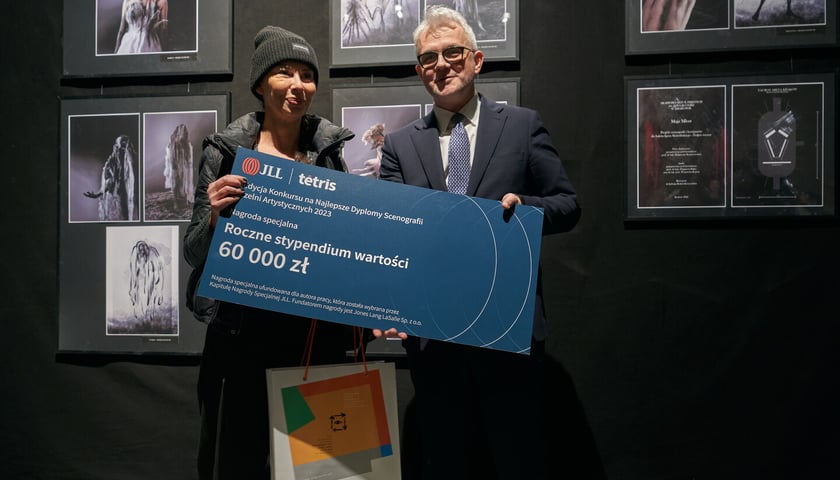 <p>Na zdjęciu wystawa w Muzeum Teatru - nagrodzone prace w II Konkursie Dyplom&oacute;w Scenografii Uczelni Artystycznych - mama Karoliny Kempińskiej odbiera za c&oacute;rkę nagrodę, stypendium od firmy JLL z rąk Mateusza Boncy z JLL</p>