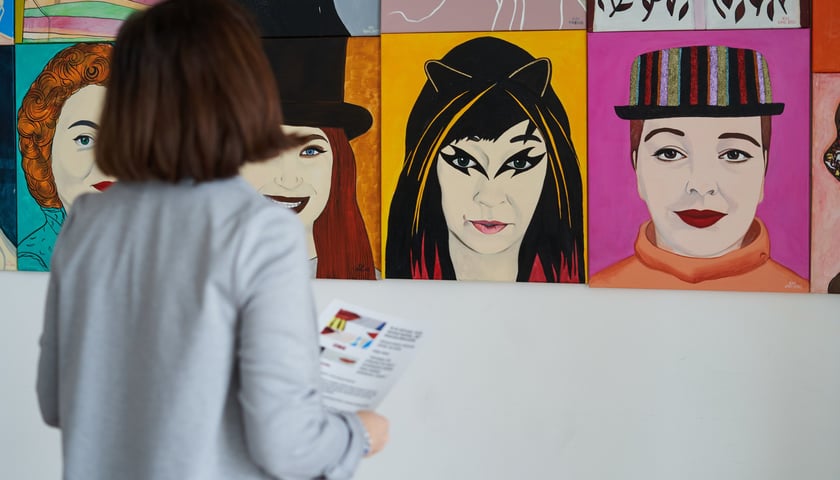 Na zdjęciu: kobieta oglądająca portrety na wernisażu wystawy "One" w CK Wrocław-Zachód