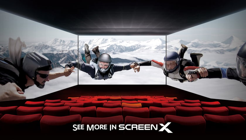 Powiększ obraz: <p>Filmy będą wyświetlane (w nowym formacie) w kinie w CH Korona. Na zdjęciu widać fotele kinowe i ekrany. Na zdjęciu widać napis po angielsku: See more in ScreenX</p>