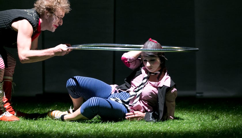 Dwie osoby w strojach cyrkowych i z kołem podczas spektaklu w teatrze pantomimy (zdjęcie ilustracyjne)