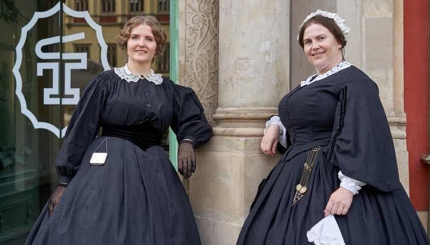 Dwie kobiety - Edyta Herczyńska i Joanna Masiak ze Stowarzyszenia Krynolina - ubrane w czarne suknie stylizowane na XIX-wieczne