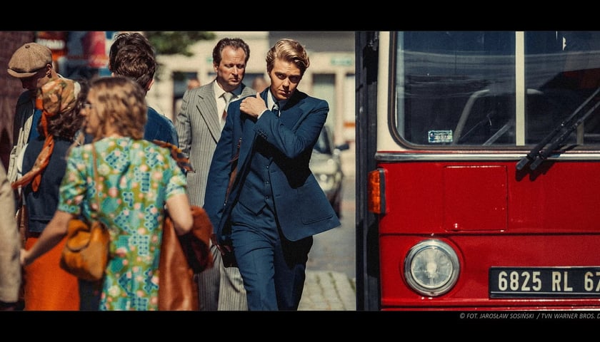 Aktor Jakub Gierszał w garniturze idzie ulicą mijając autobus, kadr z filmu „Doppelgänger. Sobowtór”