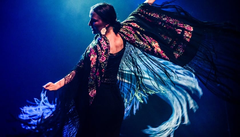 Dorota Dzięcioł z rozłożonymi ramionami tańczy na scenie flamenco w barwnej sukni, artystka wystąpi 7 października