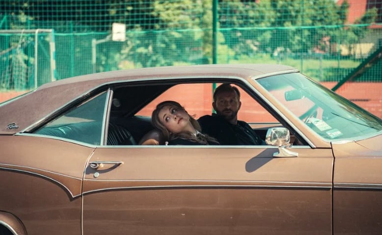 Kobieta i mężczyzna siedzą w samochodzie, kadr z filmu „Miało cię nie być”