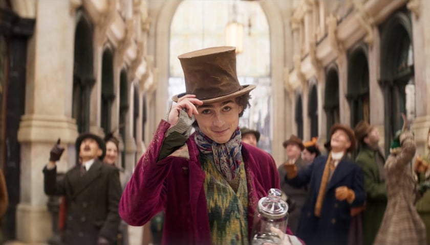 na zdjęciu Timothee Chalamet jako Willie Wonka w surducie i kapeluszu w filmie "Wonka"