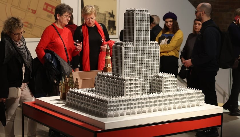 Ludzie na wystawie w Muzeum Architektury, widać makietę budowli
