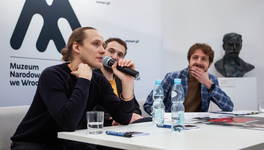<p>Bartosz Bielenia (z mikrofonem) i Paweł Maślona oraz Piotr Czerkawski podczas spotkania w Panoramie Racławickiej</p>