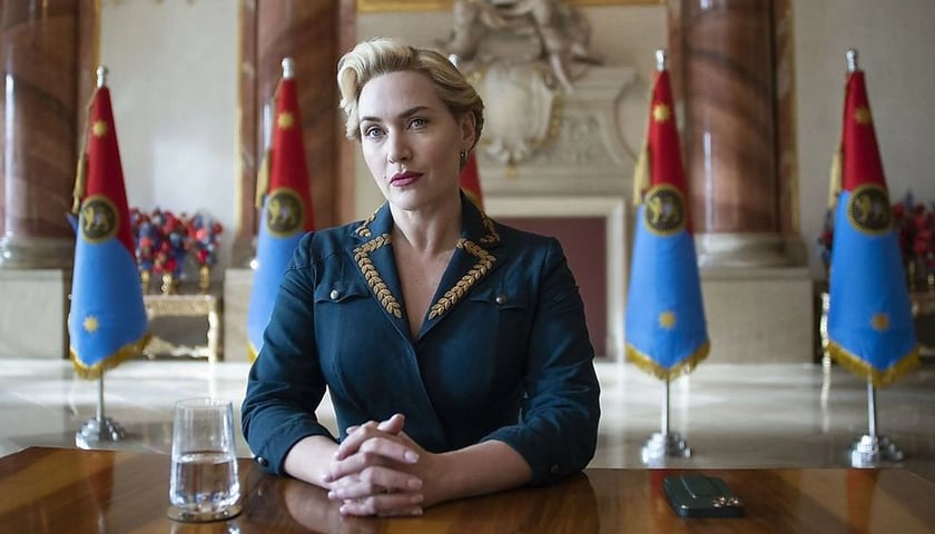 Kate Winslet w uniformie komisarz siedzi przy stole w serialu „Reżim”