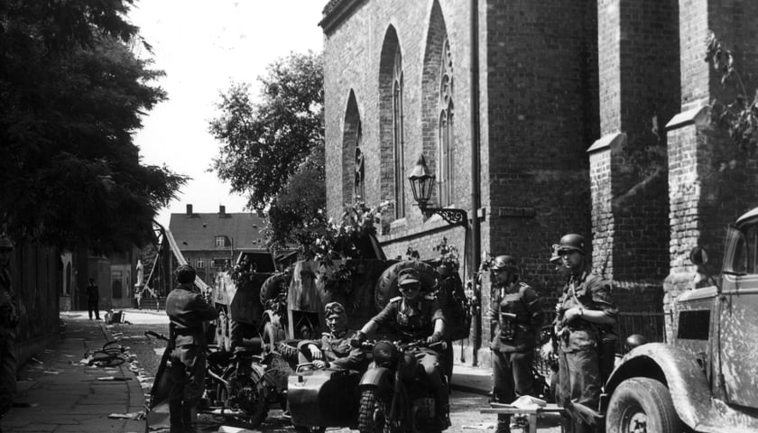 <p>Ostr&oacute;w Tumski, plan odcinka &bdquo;Poszukiwany gruppenf&uuml;hrer Wolf&rdquo;. Na motocyklu siedzą Wiktor Grotowicz i Stanisław Mikulski&nbsp;</p>
