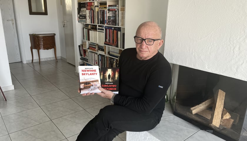 Marek Gajda, z książką, w swoim domu w Szwajcarii