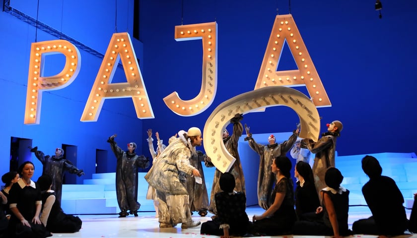 Na zdjęciu artyści na scenie w przebraniu pajaców układający napis Pajace