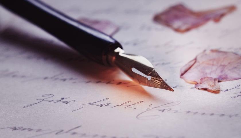 Na zdjęciu pióro wieczne na zapisanej kartce papieru