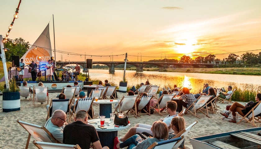 na zdjęciu plaża we Wrocławiu z leżakami i publicznością, na scenie artyści, jedno z festiwalowych miejsc Summer Vibes Festival