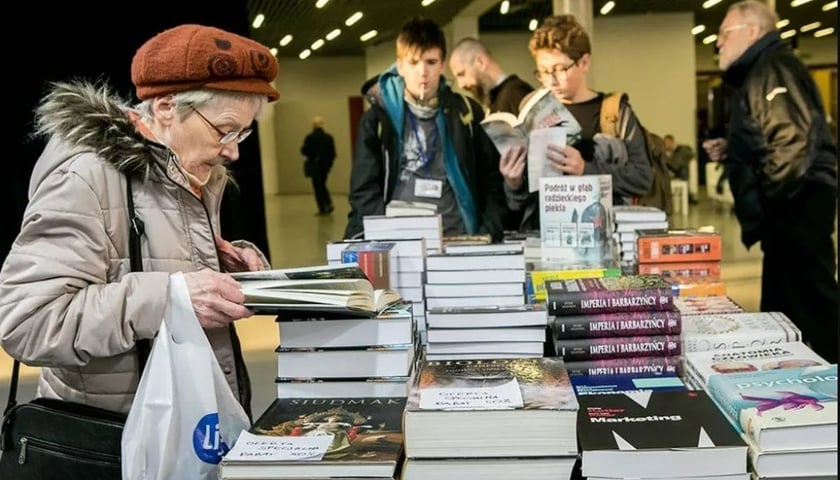 Na zdjęciu ludzie przeglądający książki