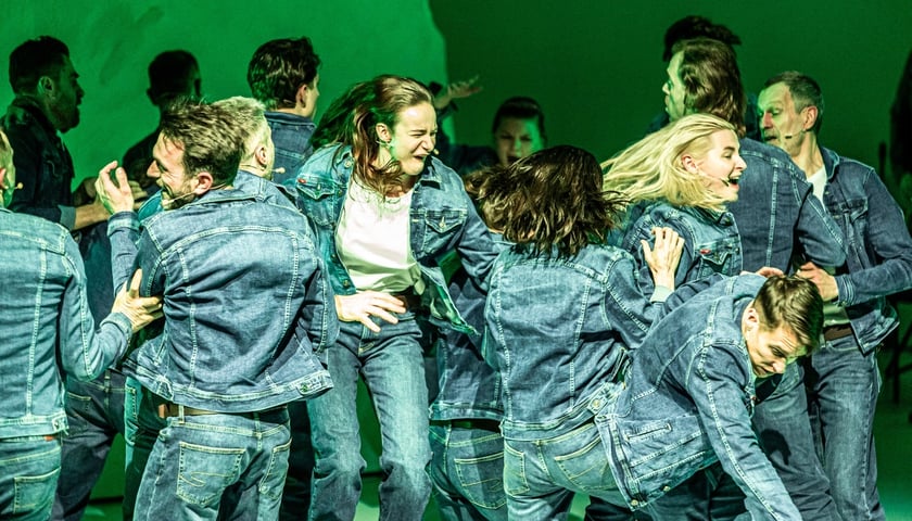 Na zdjęciu mężczyźni w dżinsowych spodniach i kurtkach walczący miedzy sobą, scena ze spektaklu „Dramat rodzaju męskiego”