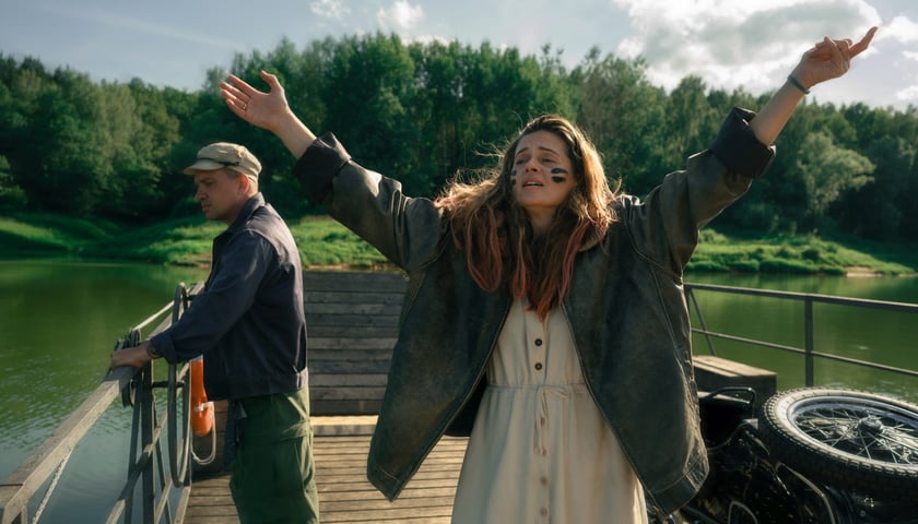 Agnieszka Grochowska (aktorka stoi z rozłożonymi do góry rękami). Kadr z filmu 