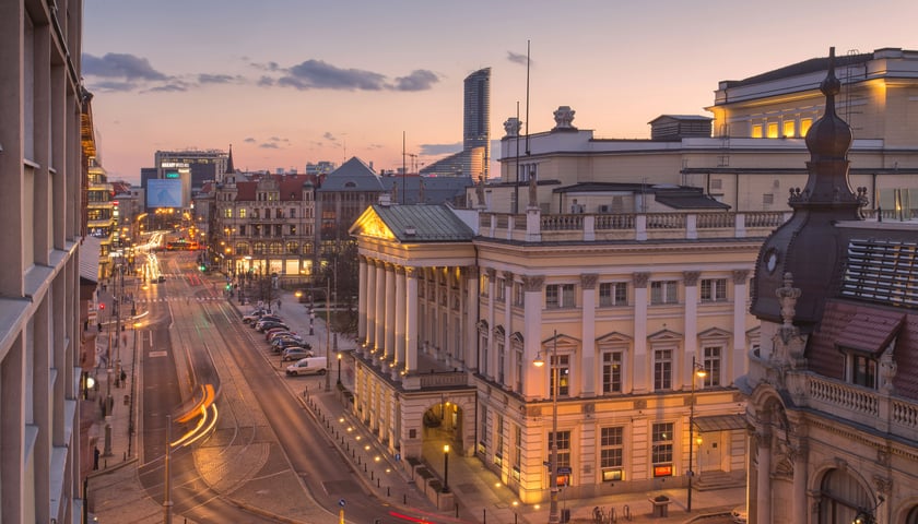 Opera Wrocławska.  Widać budynek opery i ulicę Świnicką. Zdjęcie jest zrobione wieczorem - ulica i budynki są oświetlone 
