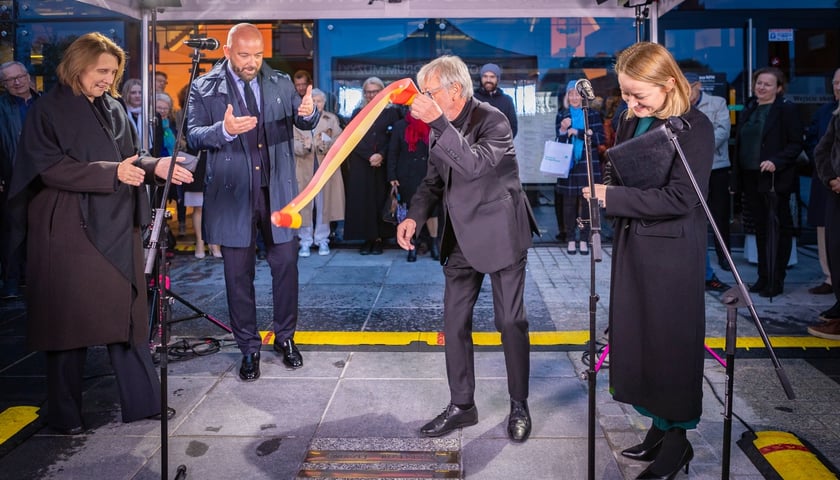 Andrzej Kosendiak odsłania swoją tablicę przed NFM. Towarzyszą mu m.in. Jacek Sutryk, prezydent Wrocławia i pani minister kultury i dziedzictwa narodowego - Hanna Wróblewska (na zdjęciu po lewej) oraz dyrektor NFM Olga Humeńczuk (na zdjęciu po prawej)