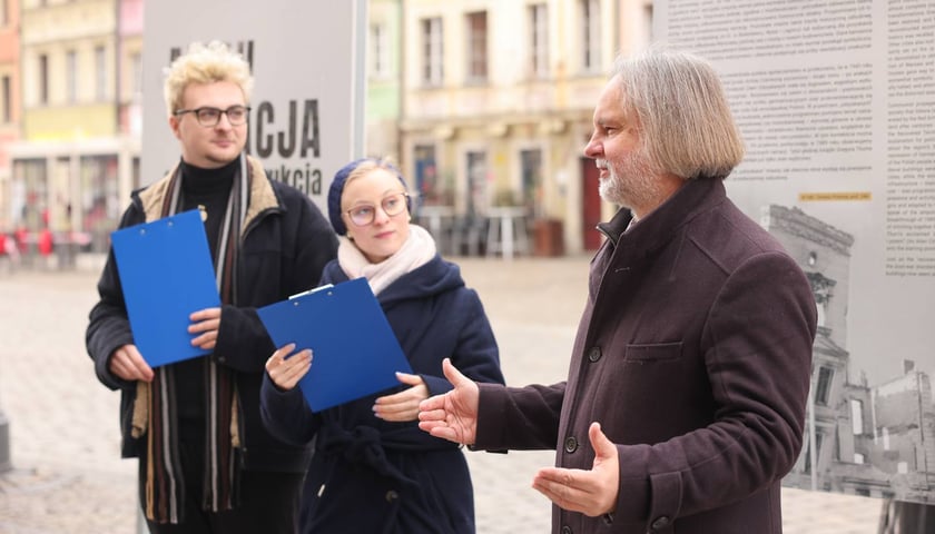 Powiększ obraz: <p>Wystawa plenerowa „Amputacja czy rekonstrukcja. Miasta południowo-zachodniej Polski po 1945 roku” w rynku do 11 marca. prof. Tomasz Przerwa z Zofią Perzyńską i Stanisławem Narlochem z II roku kierunku „Historia w przestrzeni publicznej” Uniwersytetu Wrocławskiego</p>