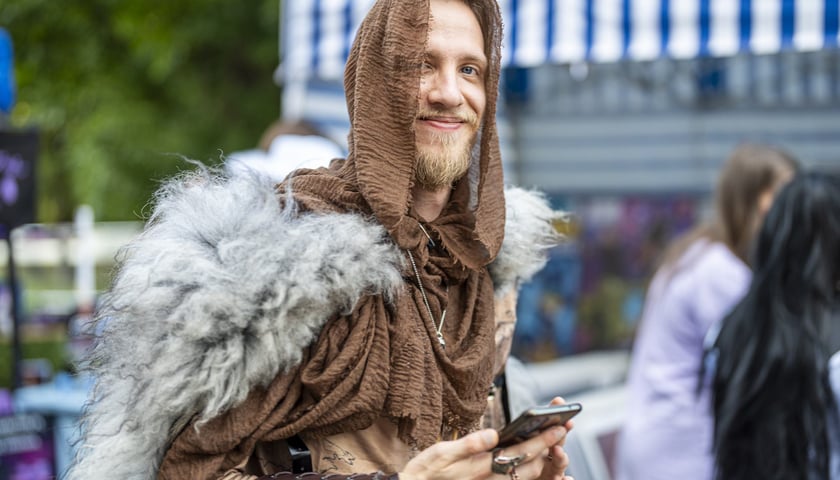 Mężczyzna w stroju wikinga ze smartfonem w dłoni, na Dniach Fantastyki 2024 we Wrocławiu