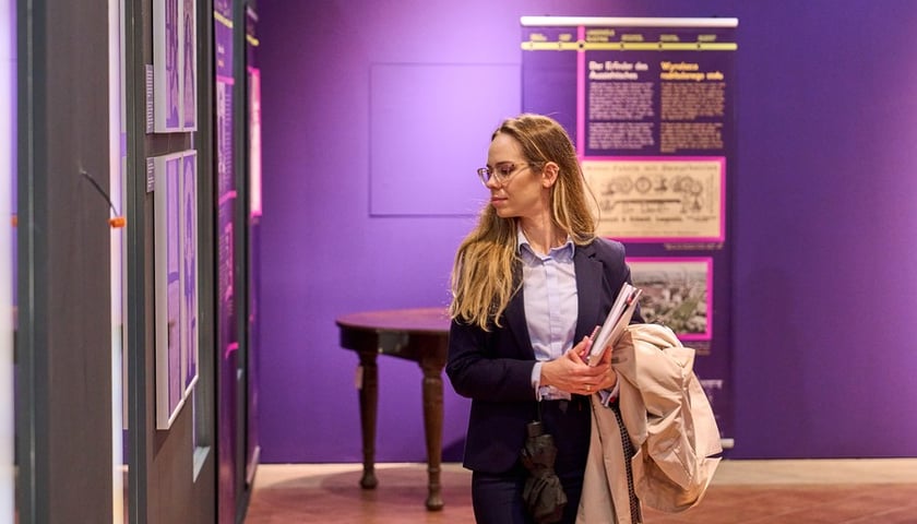 Kobieta w garniturze i okularach ogląda wystawę „Dolny Śląsk pnie się w górę” w przededniu jej otwarcia w Muzeum Etnograficznym we Wrocławiu 