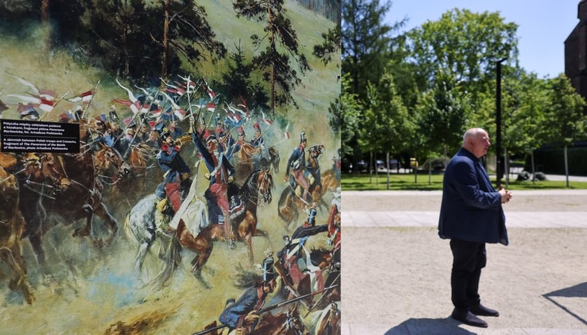 Plansza ze zdjęciem fragmentu obrazu Panorama Racławicka (skwer Wrocławianek) i dr Piotr Oszczanowski, dyrektor Muzeum Narodowego we Wrocławiu