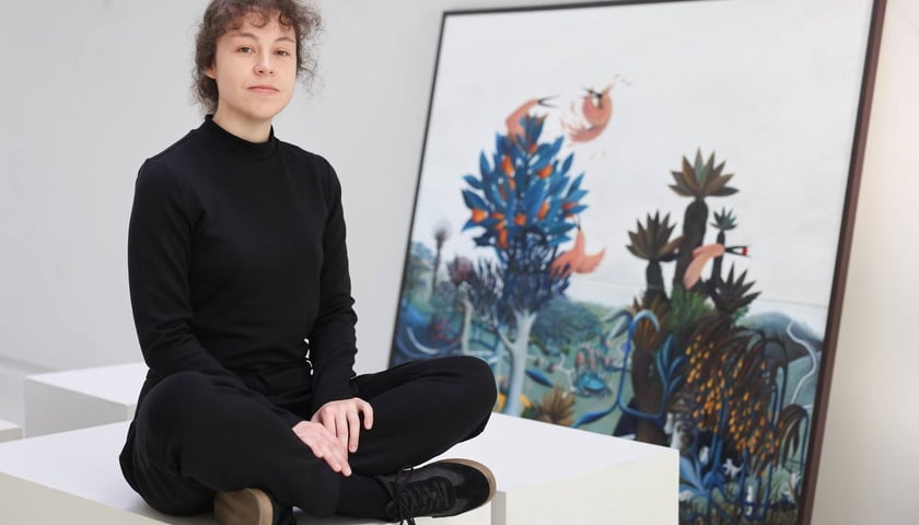 <p>Modesta Gorol przy swoim obrazie podczas przygotowań do wystawy w CK Agora</p>