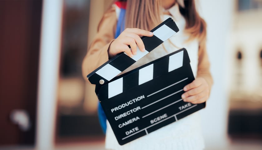 Na zdjęciu tzw. klaps filmowy trzymany przez dziewczynkę