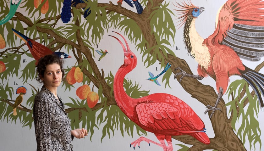 <p>Aleksandra Czudżak na tle muralu w ptaszarni w Zoo Wrocław</p>