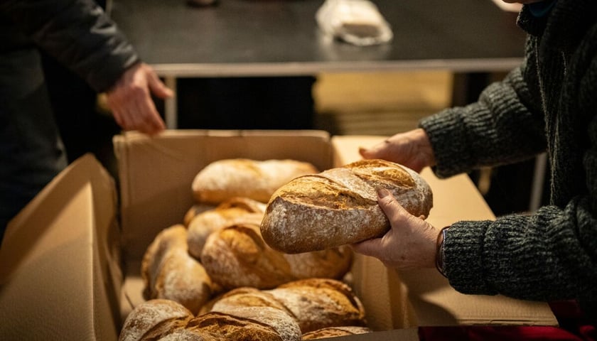 <p>bochenki chleba wyjmowane z pudła</p>