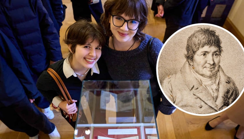 Na zdjęciu dwie dziewczyny przy gablocie z książką, na zdjęciu w kółku portret Józefa Maksymiliana Ossolińskiego