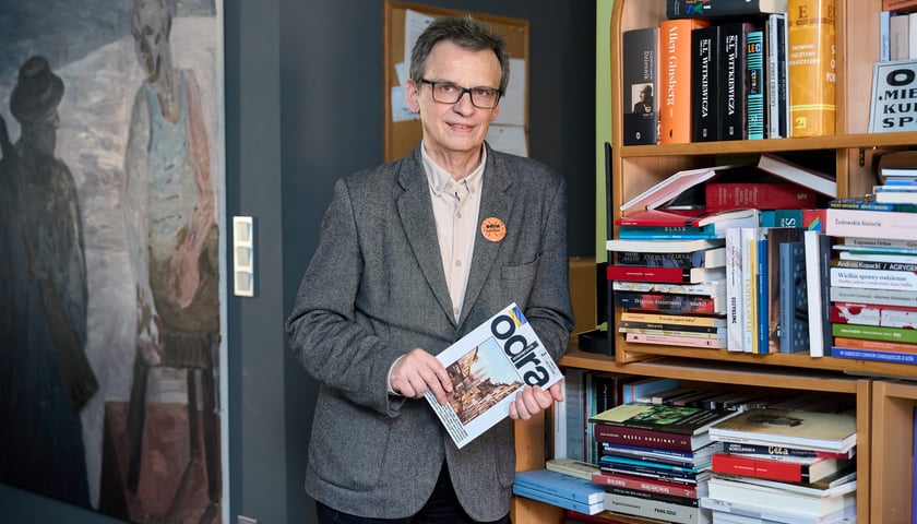 <p>Mariusz Urbanek w redakcji miesięcznika &bdquo;Odra&rdquo;, w tle obraz Edwarda Dwurnika&nbsp;</p>