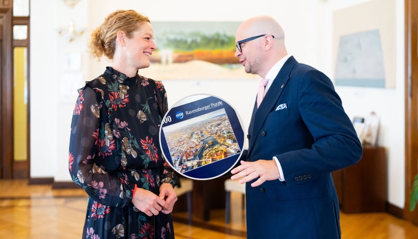 Susanne Knoche i Jakub Mazur podczas spotkania w ratuszu, w kółku są puzzle marki Ravensburger