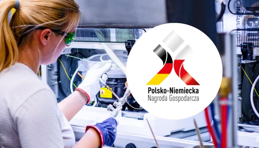 Kobieta w okularach ochronnych przy linii produkcyjnej w zakładzie BSH we Wrocławiu. Napis Polsko-Niemiecka Nagroda Gospodarcza