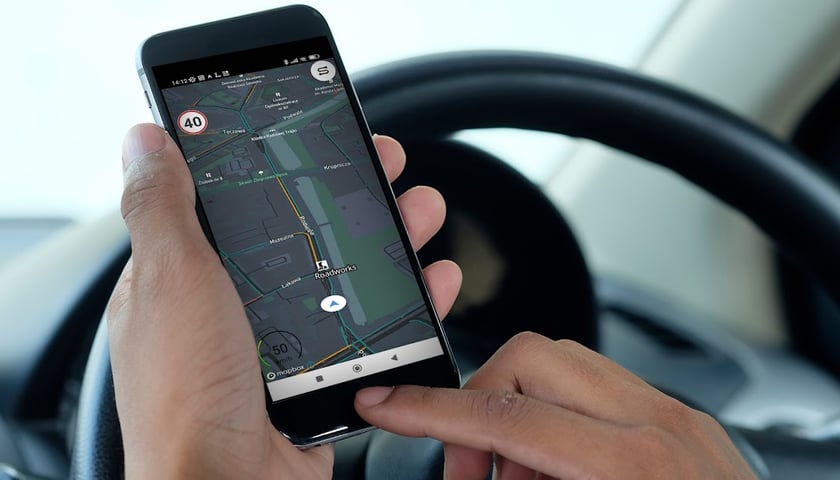 Na zdjęciu widać dłonie kierowcy i smartfon z aplikacją deeptraffic we Wrocławiu