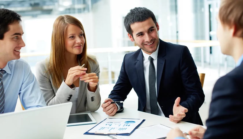 Rozmowa rekrutacyjna, cztery osoby przy biurku, zdjęcie ilustracyjne