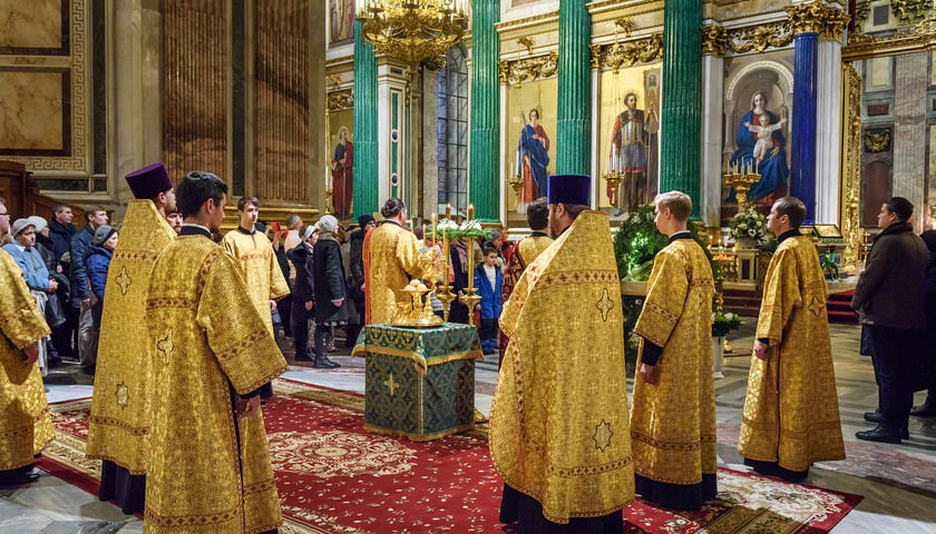 Mężczyźni i kobiety podczas nabożeństwa w cerkwi