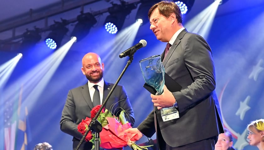 Sławomir Majchrowski, prezes Grupy Selena ze statuetkę i kwiatami w rękach, w tle Jacek Sutryk, prezydent Wrocławia 
