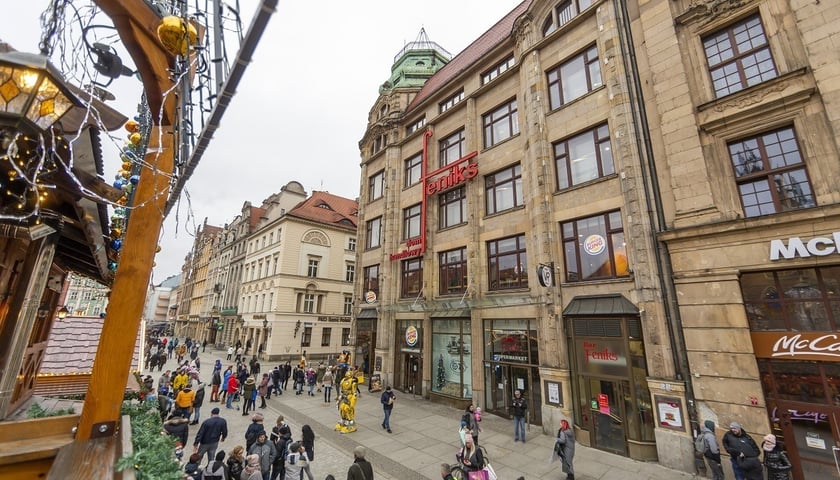 Ludzie na ulicy i gmach domu Handlowego Feniks na Rynku we Wrocławiu 